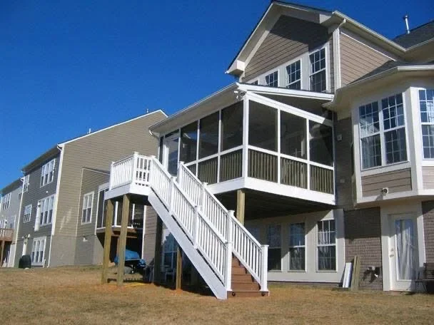 Elevated deck with white railings, screened porch, and composite decking on elevated home