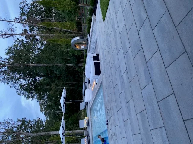 Gray concrete paver patio with running bond pattern and mature landscape borders